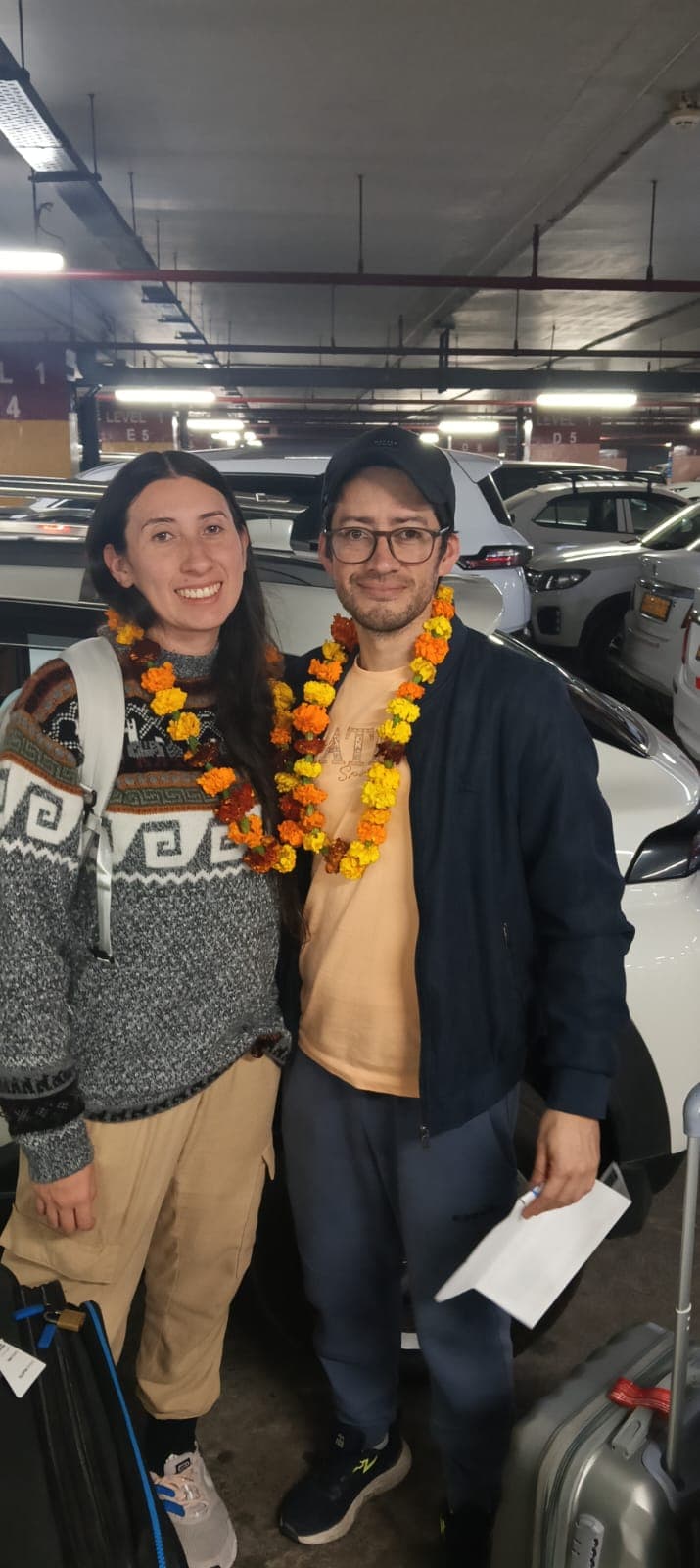 Couple with marigold garlands in parking area
